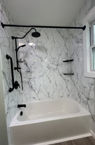 shower and bath combo with marble acrylic wall panel